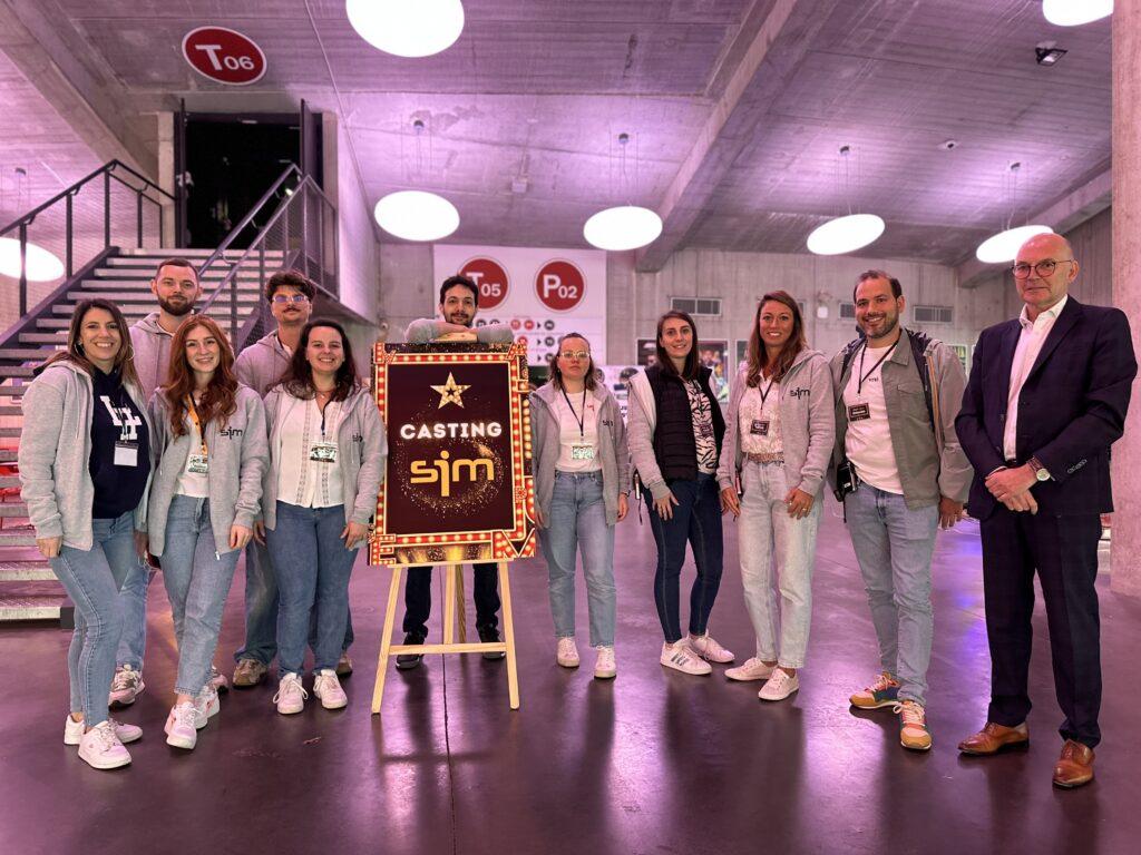 Equipe SIM posant avec la pancarte de l'événement